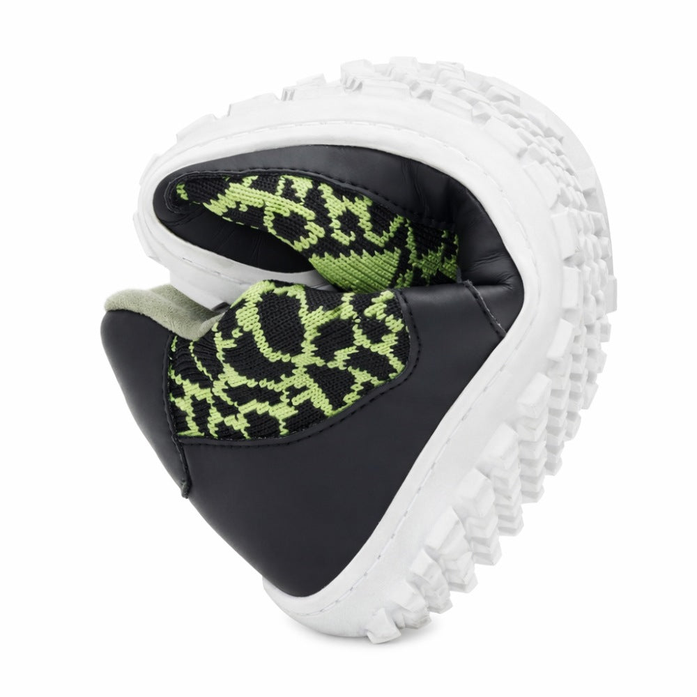 Wir präsentieren den QINGSTON Green von ZAQQ: einen Barfußschuh mit einer flexiblen, faltbaren Sohle mit einem schlangenartigen Muster auf dem schwarz-grünen Obermaterial. Dieser Schuh besteht aus veganen Materialien und verfügt über eine klobige weiße Sohle mit markanten Profilen.