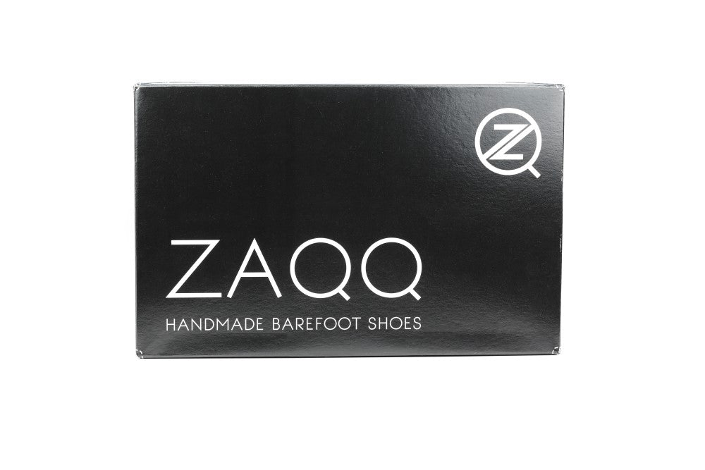 Na čiernej krabici na topánky je značka ZAQQ zreteľne zobrazená veľkými bielymi písmenami. Pod tým je hrdo napísané HANDMADE BAREFOOT SHOES. V pravom hornom rohu sa nachádza okrúhle logo s písmenom Z, ideálne pre balenie vášho QUINTIC Brogue Cognac alebo iného obľúbeného modelu barefoot topánok.