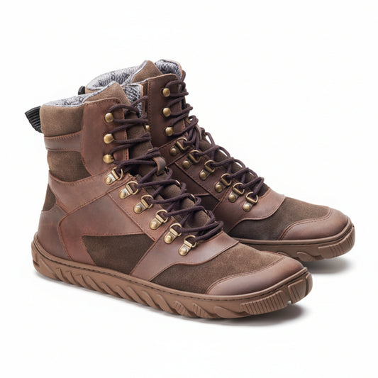 Die EXPLORER Brown Waterproof-Stiefel von ZAQQ sind aus braunem Leder und Wildleder gefertigt und verfügen über dunkelbraune Schnürsenkel und goldene Ösen. Sie verfügen über eine strukturierte Sohle für Halt und eine gepolsterte Innenseite für Komfort und zeigen ein robustes Design, das ideal für abenteuerliche Wanderungen ist.