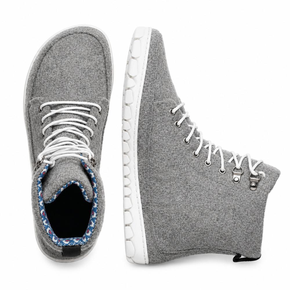 Wir präsentieren den QICE Grey von ZAQQ: Diese Sneaker haben ein High-Top-Design in Grau mit weißen Schnürsenkeln und bieten sowohl von oben als auch von der Seite einen guten Blick. Ihr herausragendes Merkmal ist eine einzigartig strukturierte Outdoorsohle, die für mehr Stil und Komfort sorgt. Sie sind aus Merinowolle ähnlichen Materialien gefertigt und bieten eine auffällige Mischung aus Komfort und Mode.