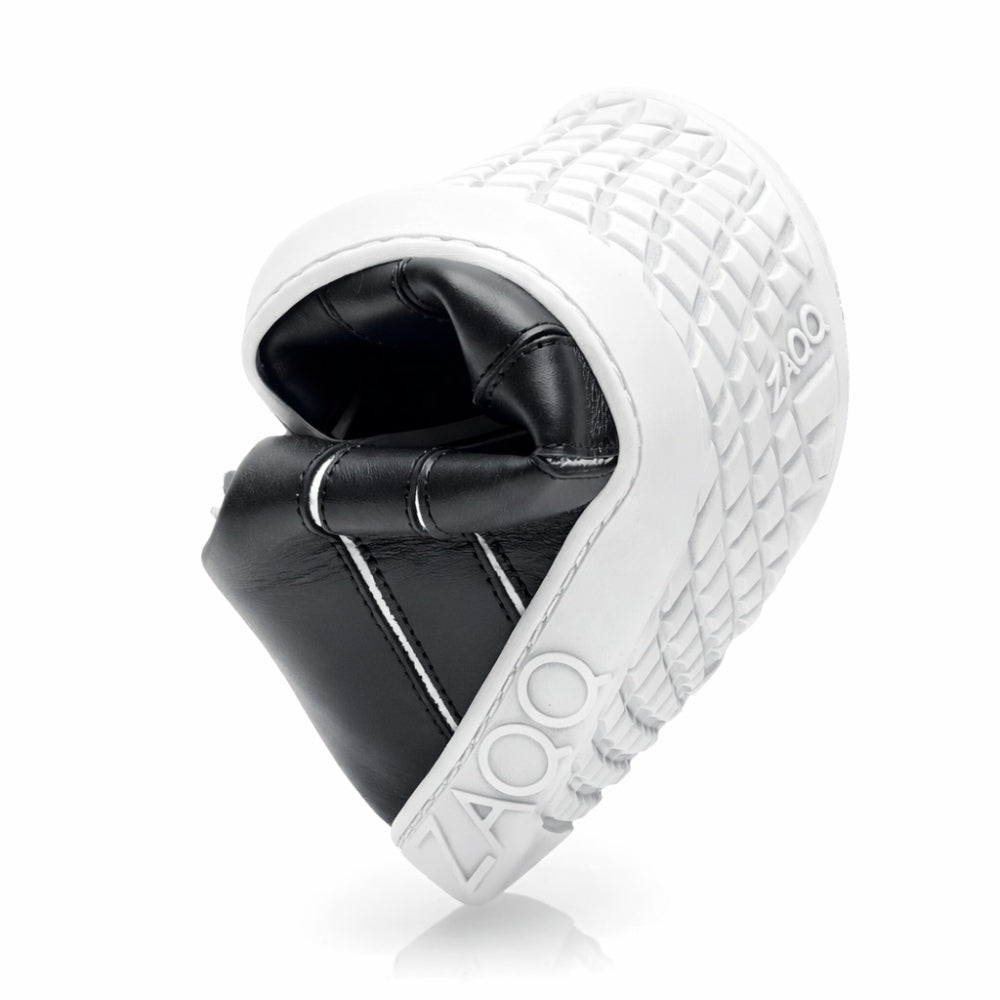 Nahaufnahme des ZAQQ QQQ Mid Black White-Sneakers mit nach oben gefalteter flexibler Sohle. Dieser elegante Schuh ist aus Nappaleder gefertigt, hat ein schwarzes Design mit weißer strukturierter Sohle und dem elegant auf der Seite eingeprägten Markennamen.