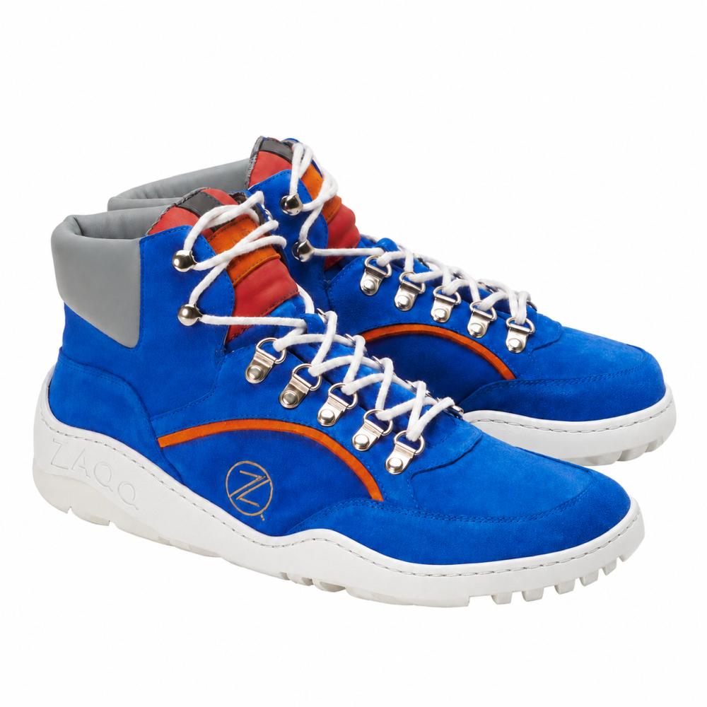 Tieto žiarivo modré vysoké tenisky od ZAQQ, model TREQ Azure Waterproof, majú biele šnúrky a strieborné očká. Majú oranžové a červené akcenty, šedú polstrovanú oblasť členku a robustnú ZAQQ TERRA podrážku. Okrúhle logo na boku dodáva topánke nezameniteľný charakter.